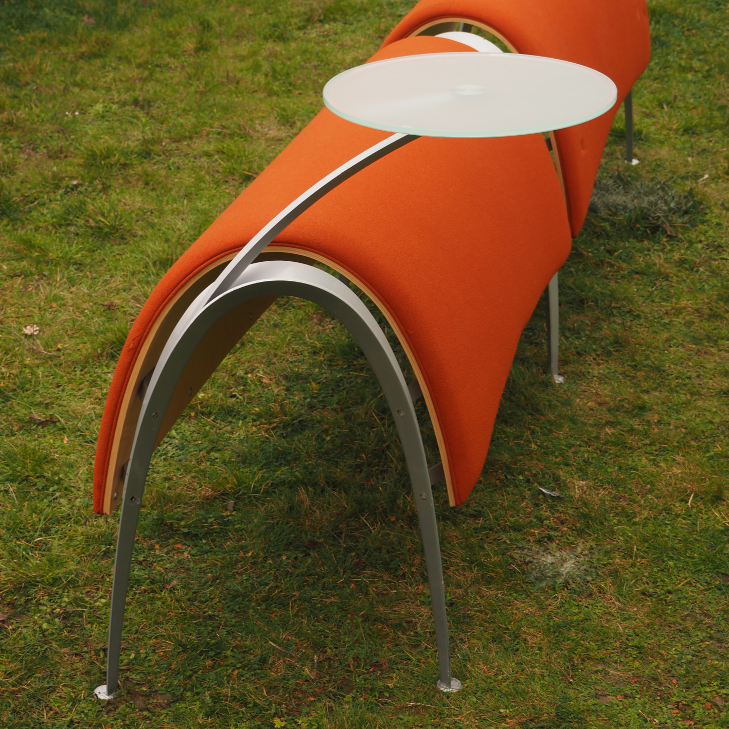 Double waiting bench in curved plywood and textile cover with glass tablet