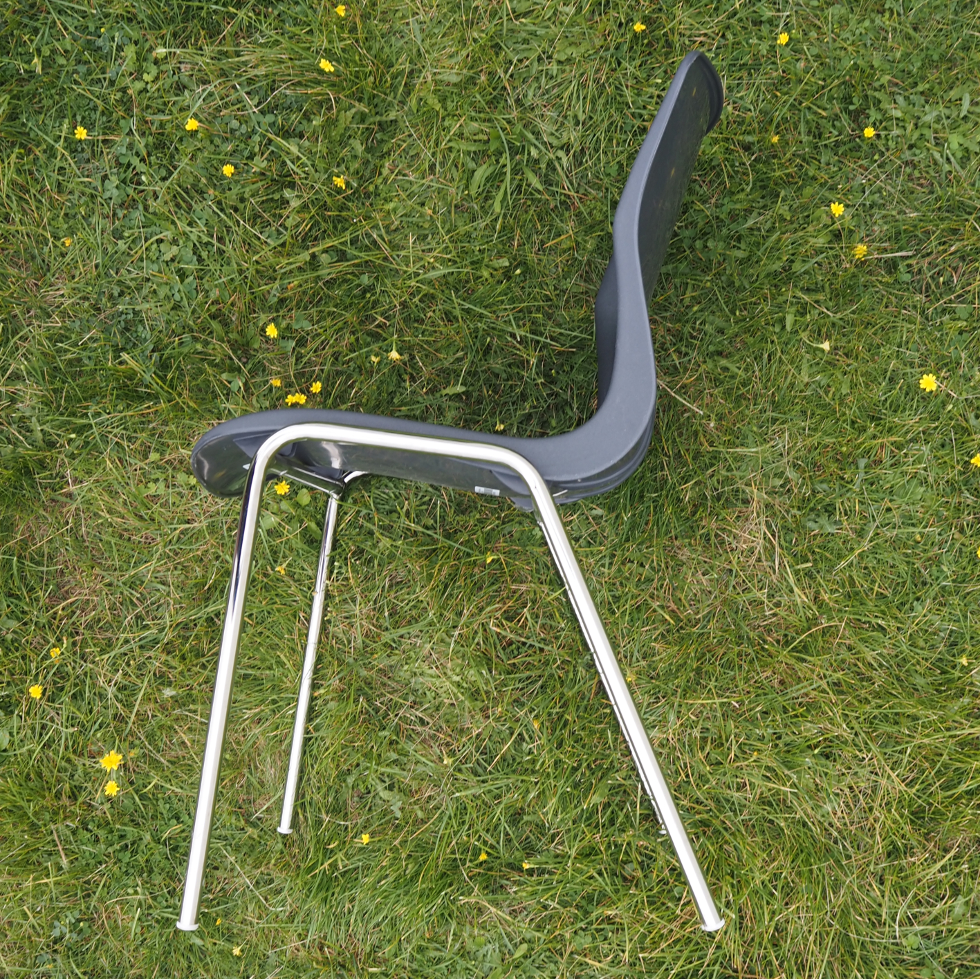 Stackable chair with anthracite polypropylene shell and tubular steel legs