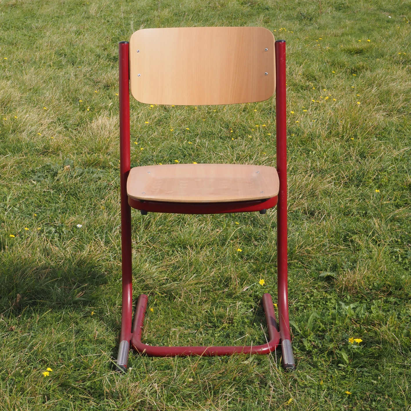 Cantilever chair with textured plywood seat and steel legs