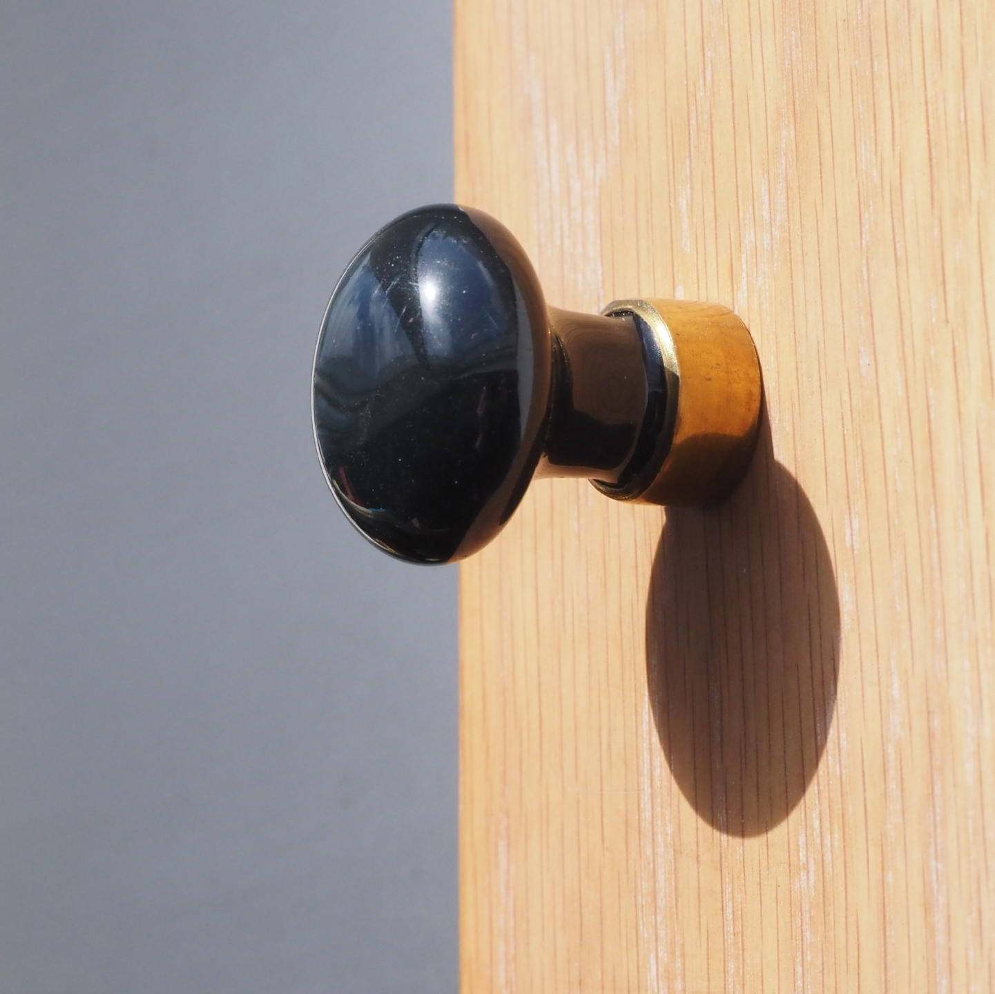 Cabinet knob in black porcelain and brass