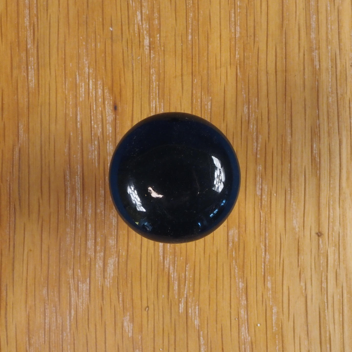Cabinet knob in black porcelain and brass