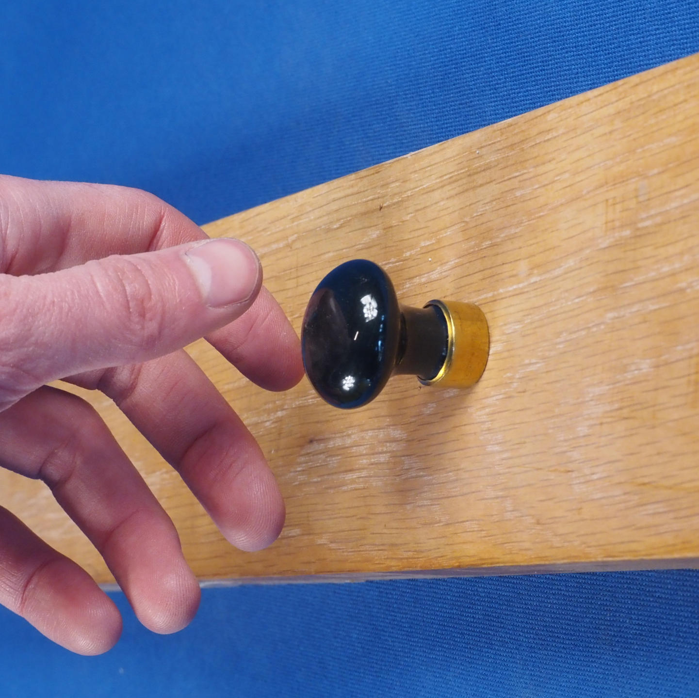 Cabinet knob in black porcelain and brass