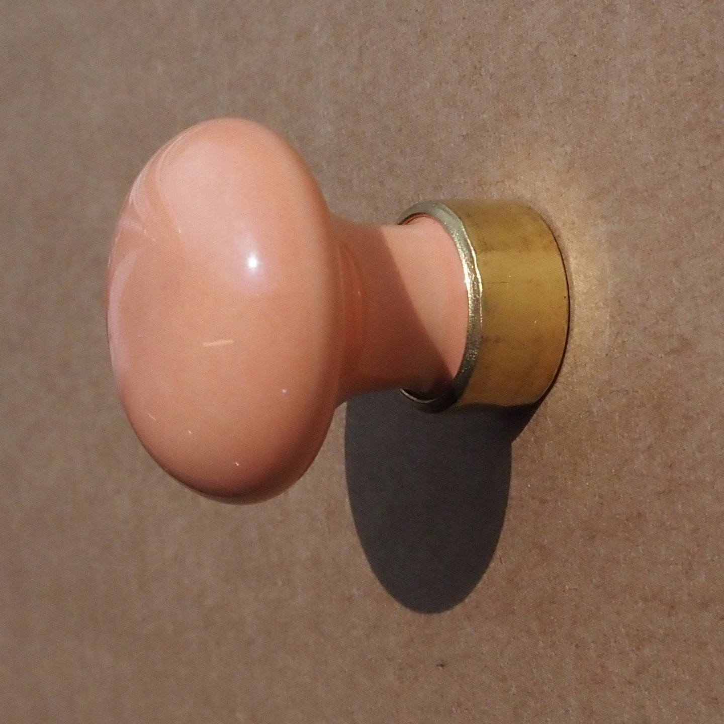 Cabinet knob in salmon pink porcelain and brass