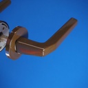 Door handle in brown coated stainless steel with key rosettes