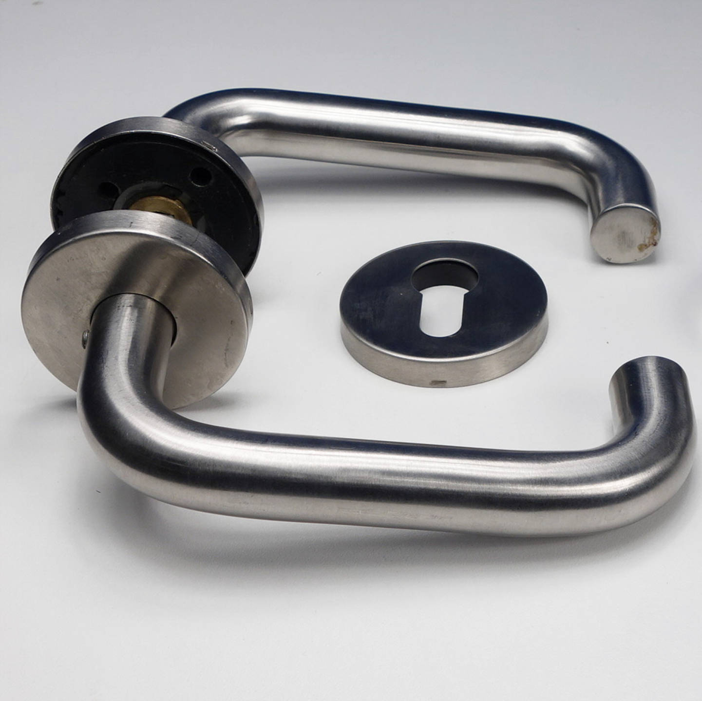 Door handle in stainless steel with key rosettes