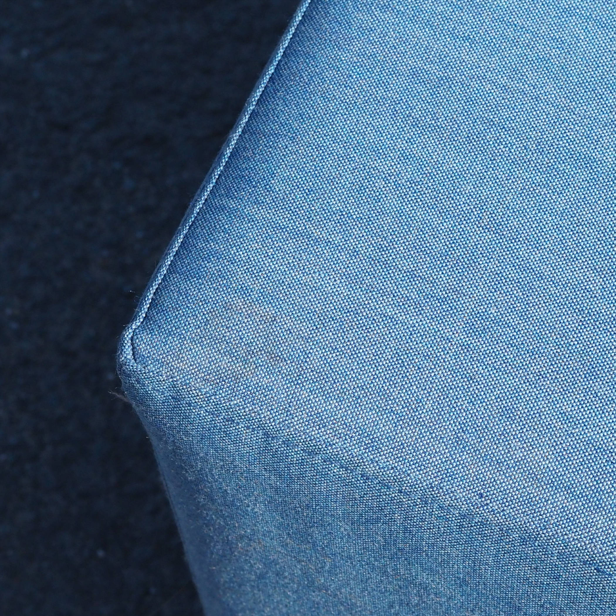 Square ottoman upholstered in grey or blue fabric