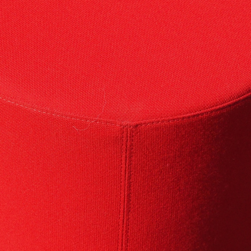 Round ottoman upholstered in various colorful fabric