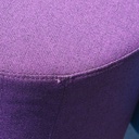 Round ottoman upholstered in various colorful fabric