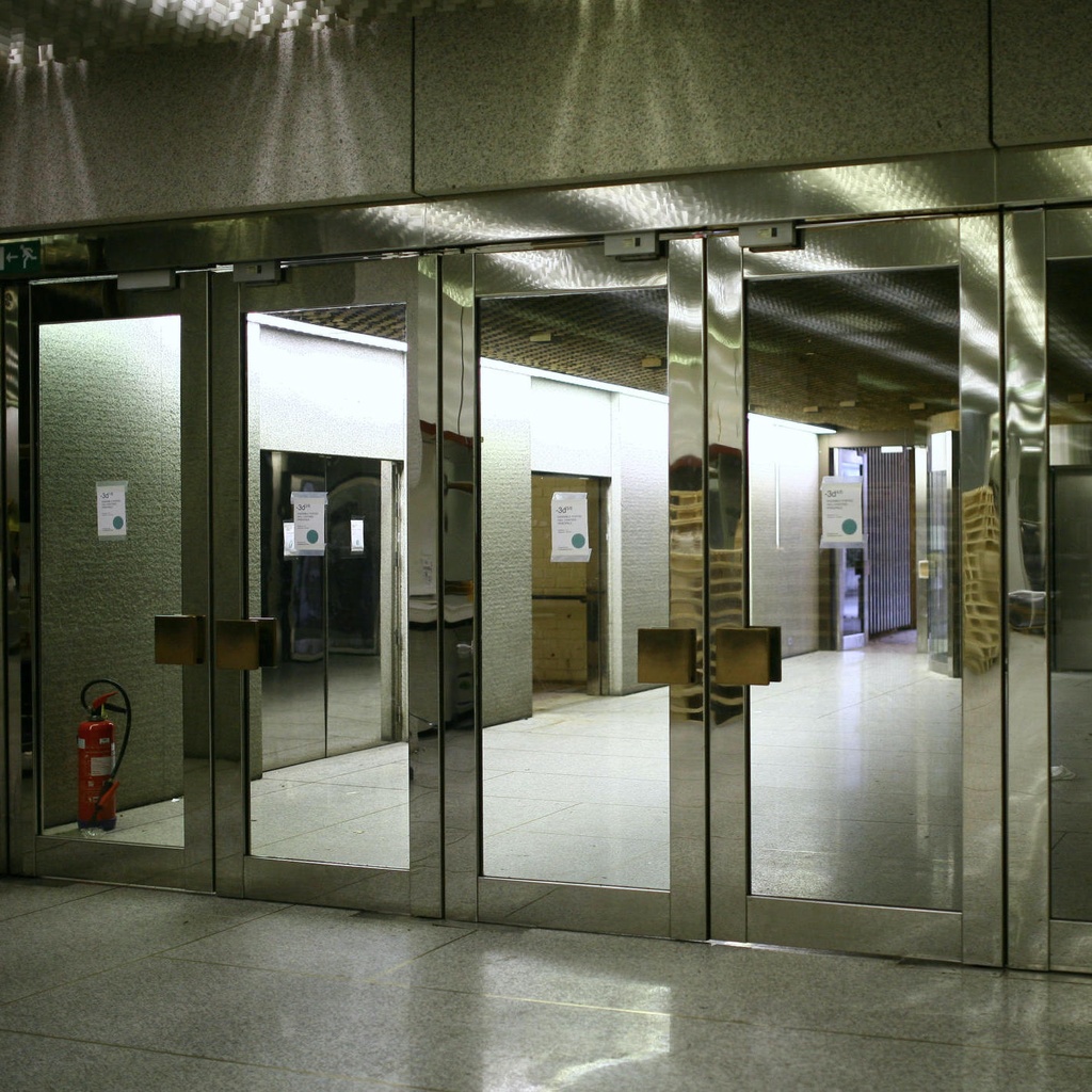 Glass door in stainless steel and bronze from the main entrance of the Générale de Banque(H. 235,5 x 108 cm)