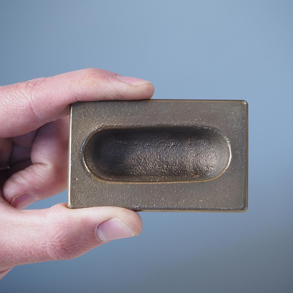 Small inset cabinet handle in sand-cast bronze by Jules Wabbes from the Générale de Banque