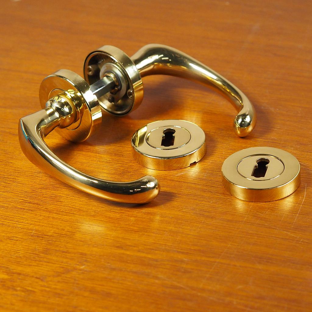 Door handle in brass plated aluminium with key rosettes by Linea Bertomani