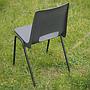 Stackable chair with black polypropylene shell and tubular steel legs