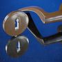 Door handle in brown coated stainless steel with key rosettes