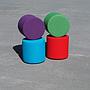 Round ottoman upholstered in various colorful fabric
