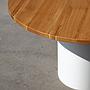 Round dining table with wooden top and white-painted steel base